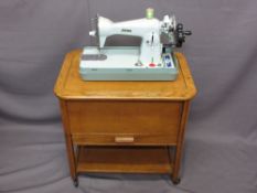 JONES DELUXE HAND CRANK SEWING MACHINE with an oak needlework/sewing box trolley and contents