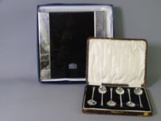 SILVER EDGED PHOTOGRAPH FRAME and a cased set of teaspoons, Sheffield hallmarks for 2006 and 1932