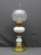BRASS & WHITE MILK GLASS VICTORIAN OIL LAMP with decoration in relief and frosted globular shade,