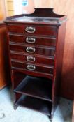 MAHOGANY RAIL-BACK FIVE DRAWER MUSIC CABINET with a two shelf base