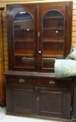 EARLY 20TH CENTURY MAHOGANY BOOKCASE-CUPBOARD with brass fittings, two drawers above a two drawer