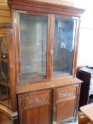 CONTINENTAL BOOKCASE-CUPBOARD with carving to doors, brass decorated hinges, 224cms tall x 122cms