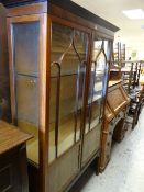 EDWARDIAN FLAME MAHOGANY TWO DOOR DISPLAY CABINET on raised feet with astragal glazed doors,