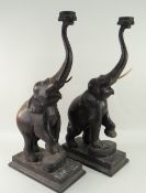 PAIR OF VINTAGE CARVED ELEPHANTS with trunks raised and standing over rectangular bases, 63cms high