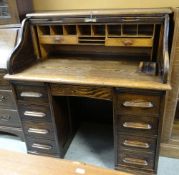 VINTAGE OAK ROLL-TOP DESK with centre drawer flanked by two banks of four drawers, 116cms wide