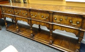 GOOD REPRODUCTION DRESSER BASE having a bordered open rack, ogee-type frieze, four deep drawers with