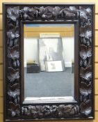 CARVED OAK MIRROR, the border applied with hops vine in deep relief, label verso F Dredge Cabinet