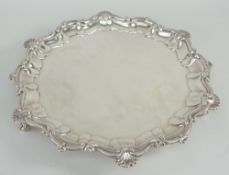 EDWARD VII SILVER SALVER having shell and scroll border, raised on three ball and claw feet,