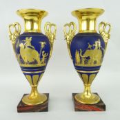 PAIR OF CLASSICAL TWIN-HANDLED PEDESTAL VASES decorated with figures and animals on a blue ground