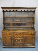 NORTH WALES OAK DRESSER, the three shelf rack with shaped frieze and sides having wide back