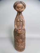 MARGIT KOVACS POTTERY FIGURINE of a young girl holding a jug, incised monogram to the base, 23cms