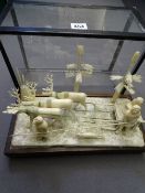 LATE 19th CENTURY INUIT CARVED BONE ESKIMO SCENE set upon a wooden stand, depicting a family group