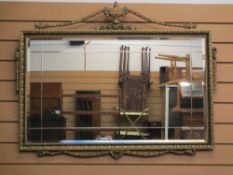 GILT FRAMED WALL MIRROR with urn and swag detail and bevelled edge glass, 76 x 97cms