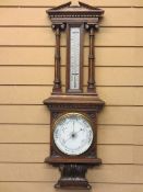 CIRCA 1900 OAK FRAMED ANEROID BAROMETER WITH THERMOMETER in the architectural style, 92cms H,