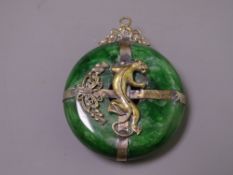 LARGE GREEN STONE CHINESE PENDANT with metal mount of writhing panther and top ring attachment, 5cms