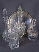 FOUR GLASS DECANTERS with stoppers on a circular EPNS tray, two having ceramic labels for sherry and