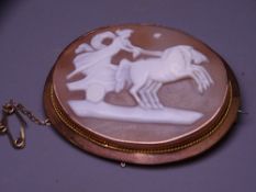 LARGE NINE CARAT GOLD FRAMED CAMEO BROOCH, the 4.5cms cameo carved with a Greek Goddess in a horse
