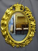 CARVED BLACK FOREST OVAL WALL MIRROR, late 19th Century, gilded with lily of the valley, oak and