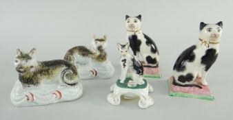 VICTORIAN CAT MODELS, pair of Staffordshire recumbent cats, two seated on cushions and a porcelain