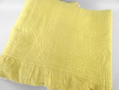 ANTIQUE WELSH QUILT in daffodil yellow, spiral design with larger centred motif, border skirt,