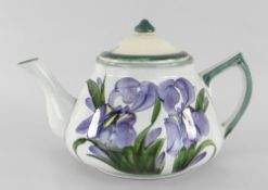 A LLANELLY POTTERY TEAPOT painted with purple irises, stencilled Llanelly to base, 21cms spout to
