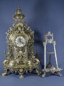ROCOCO BRASS MANTEL CLOCK and an easel frame, the clock being antique style cast in pierced and