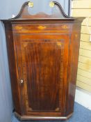 ANTIQUE MAHOGANY CORNER CUPBOARD with broken swan neck pediment over a single opening door with