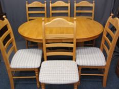 MODERN LIGHTWOOD EXTENDING DINING TABLE on substantial pedestal supports with six ladderback