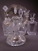 DECANTERS. A silver collared decanter and 6 others and 2 white metal spirit collars on chains.