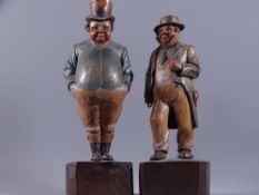 A PAIR OF CONTINENTAL CARVED WOODEN FIGURES, each of a portly standing gent,24cms high on square