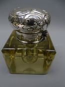 A FINE HEAVY GLASS INKWELL with 900 silver hinged and scrolled lid with band