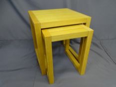 A PAIR OF GRADUATED MODERN LIGHTWOOD SQUARE COFFEE TABLES.