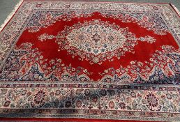 SUPER KESHAN RED GROUND CARPET classically patterned with tasselled ends, 275 x 365cms