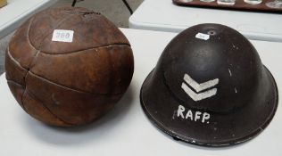 VINTAGE LEATHER MEDICINE BALL & WWII TIN HELMET PAINTED 'RAFP' & CORPORAL STRIPES (2)