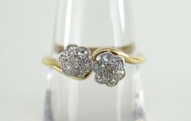 18CT YELLOW GOLD SET DIAMOND CROSS-OVER RING having two flower-heads of seven diamonds each, 2.5gms