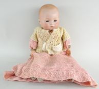 ARMAND MARSEILLE BISQUE HEAD DOLL having open eyes, composition hands and cloth body, 42cms high