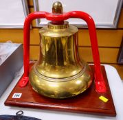 BRASS FIRE STATION BELL suspended on a red painted frame to a rectangular wooden mount, bell diam.
