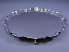 SILVER SALVER, of plain form, uninscribed and with stepped, wavy rim and three scrolled supports,