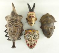 THREE BAULE MASKS including one with painted details and a Sri Lankan polychrome Hanuman mask (4)