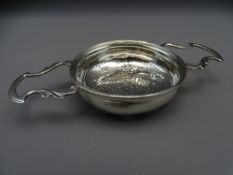 SILVER LEMON STRAINER with twin leaf form handles and star pattern pierced base of Georgian style,
