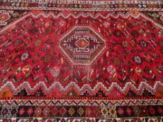VINTAGE IRANIAN WOOL CARPET - red ground with traditional central motif and multi-bordered edge, 270