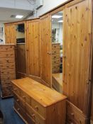 MODERN PINE FOUR PIECE BEDROOM SET of two triple wardrobes with central mirrored doors on multi-