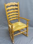 VINTAGE LADDERBACK FARMHOUSE ROCKING ARMCHAIR, rush seated, 98cms H, 56.5cms W, 41cms D the seat