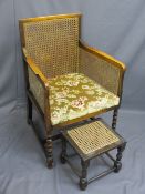 VINTAGE BERGERE ARMCHAIR on bobbin front supports and a similarly styled footstool, 95cms H, 60.5cms