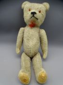 CIRCA 1910/20 BABY TEDDY BEAR with jointed limbs and glass eyes, 29cms long
