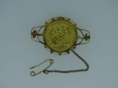 1914 GOLD HALF SOVEREIGN in a mount with pin and safety chain, 7.5grms