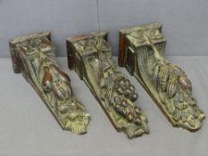 MAHOGANY WALL BRACKETS, a set of three, all with carved fruit and floral decoration to the columns