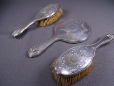 THREE PIECE SILVER BACKED DRESSING TABLE SET, each piece of attractive floral garlands (silvering to