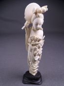 CIRCA 1910 JAPANESE IVORY FIGURINE of a floral bedecked lady holding a mirror behind her head on a