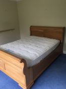 A MODERN OAK EFFECT DOUBLE SLEIGH BED WITH SLATS